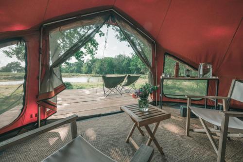 une tente rouge avec une table et des chaises dans l'établissement Les Toiles du Cassis, à Plassac-Rouffiac