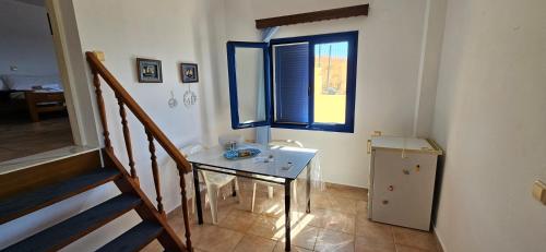 een kleine kamer met een tafel en een raam bij Ra's Seacastle in Tsoútsouros