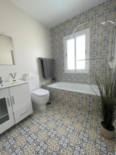 a bathroom with a toilet and a tub and a sink at Salida Del Sol in Nerja