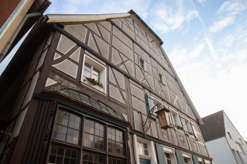 a tall building with windows and flowers on it at Gasthaus Benke, Fachwerkhaus in Westfalen in Datteln