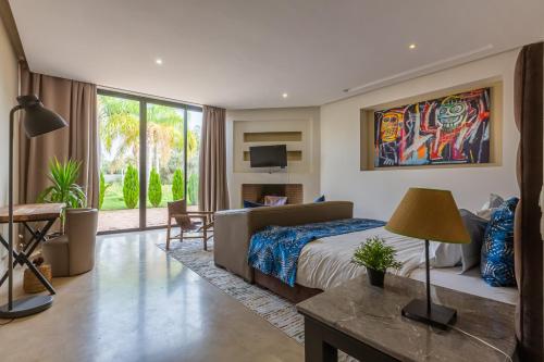 a bedroom with a bed and a desk and a tv at Villa Tomazo in Marrakech