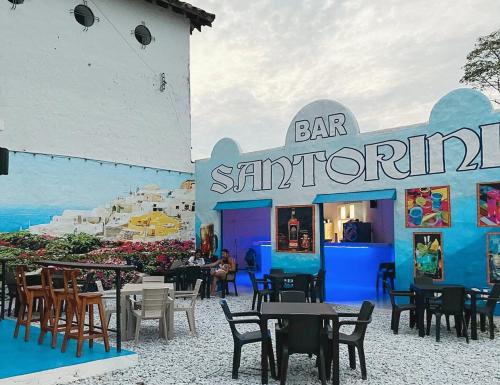 a bar with tables and chairs in front of a restaurant at El santorini colombiano cabaña in Puerto Triunfo