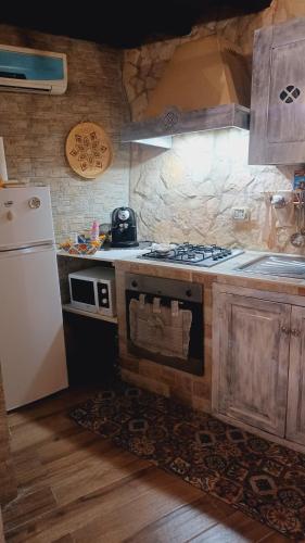 a kitchen with a stove and a refrigerator at L'antico vicolo in Nunziata