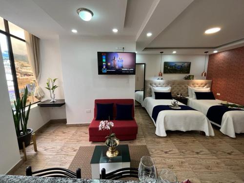 pokój hotelowy z 2 łóżkami i kanapą w obiekcie Otavalo Suites w mieście Otavalo