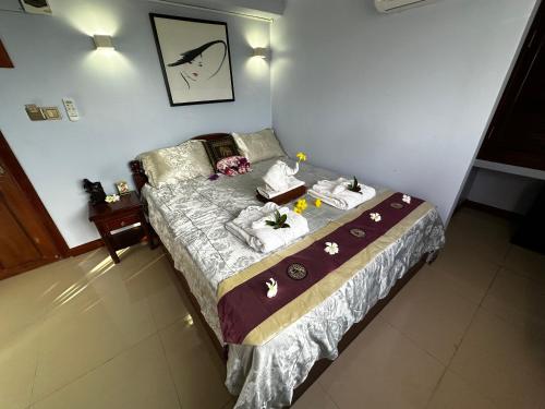 a bedroom with a bed with towels on it at Hawaii Lounge in Sihanoukville