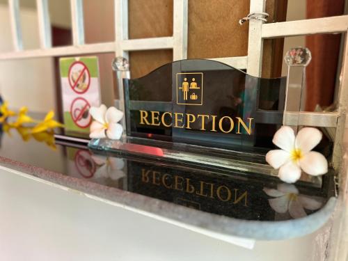 a sign on a door with flowers on it at Hawaii Lounge in Sihanoukville