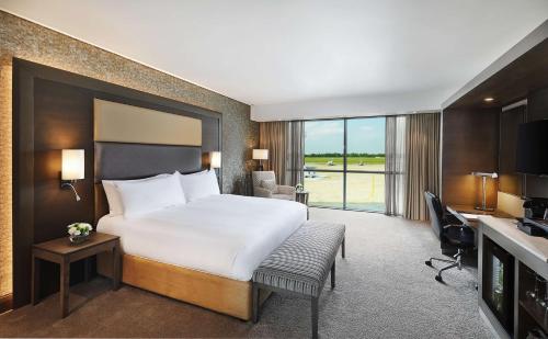 a hotel room with a large bed and a desk and a desk at Legend Hotel Lagos Airport, Curio Collection By Hilton in Lagos