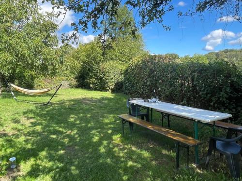 a picnic table and a hammock in a yard at Maison Lavande in Blismes