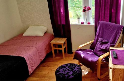 ein Schlafzimmer mit einem Bett, einem Stuhl und einem Fenster in der Unterkunft Berggården Vandrarhem in Gnarp