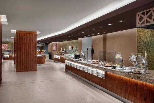 a restaurant with a counter with food on it at Doubletree By Hilton Jabal Omar Makkah in Makkah