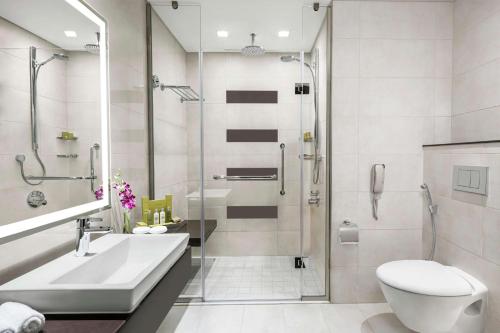 a bathroom with a shower and a sink and a toilet at Doubletree By Hilton Jabal Omar Makkah in Makkah