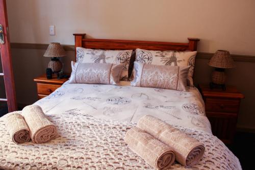 a bed with two towels and pillows on it at Victoria Heights B&B in George