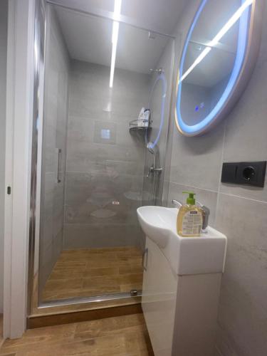 a bathroom with a shower and a sink and a mirror at Monaco in Chişinău