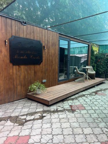 a building with a wooden deck with a table and a chair at Monaco in Chişinău