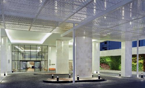 Hilton Garden Inn Muscat Al Khuwair في مسقط: لوبي مبنى بسقف مع اضواء