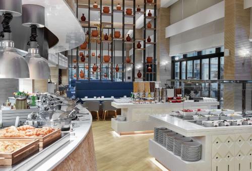 a restaurant with a buffet line with food on display at Hilton Garden Inn Muscat Al Khuwair in Muscat