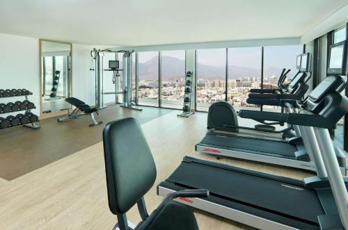a gym with cardio machines and a view of a city at Hilton Garden Inn Muscat Al Khuwair in Muscat