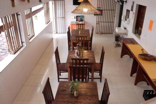 um restaurante vazio com mesas e cadeiras de madeira em Pousada Recôncavo em São Félix