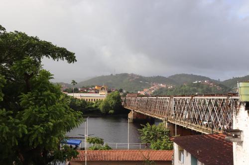 een trein die een brug over een rivier oversteekt bij Pousada Recôncavo in São Félix