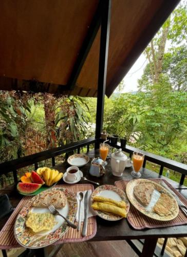 a table with plates of food and fruit on it at Fair View Cottage in Ella