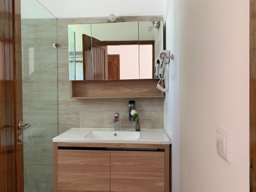 W łazience znajduje się umywalka i lustro. w obiekcie CASA MOZITA w mieście Vilanculos