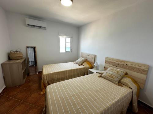 ein Hotelzimmer mit 2 Betten und einem Fenster in der Unterkunft AYAMONTE SUNSET in Ayamonte
