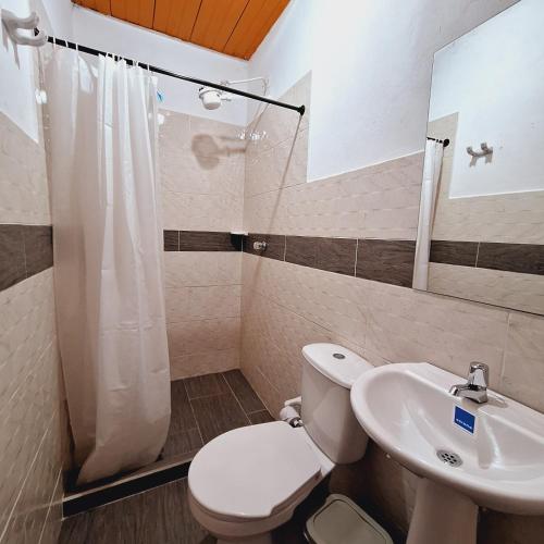a bathroom with a toilet and a sink at Hostal Colombian Gold in San Gil