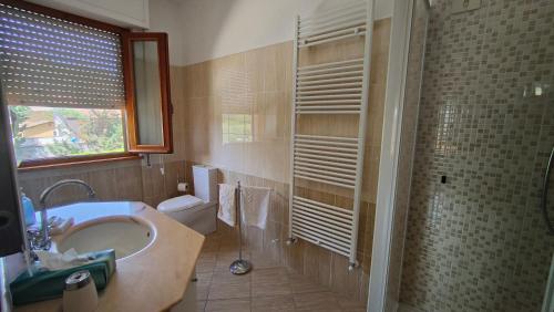 La salle de bains est pourvue de toilettes, d'un lavabo et d'une douche. dans l'établissement Cecco di Nara, à Massarosa