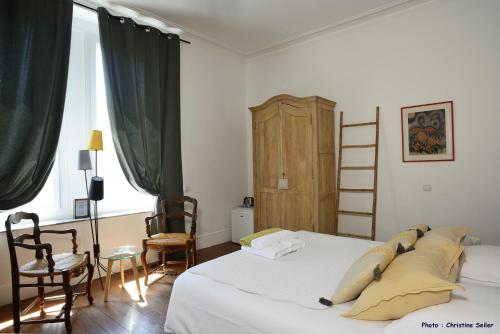 a bedroom with a bed and two chairs and a ladder at Un Nid en Camargue in Salin-de-Giraud
