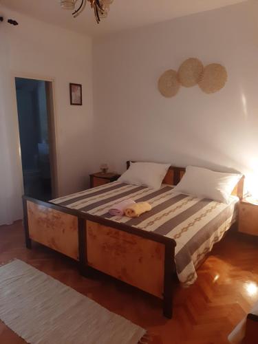 a bedroom with a bed with a stuffed animal on it at Apartments and rooms LJUBICA in Lun