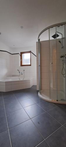 een grote badkamer met een douche en een bad bij Haus Florian in Mayrhofen