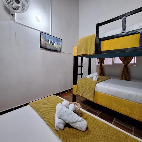 a bedroom with two bunk beds and a tv at Hostal Colombian Gold in San Gil