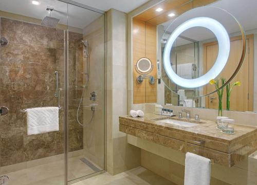 y baño con ducha, lavabo y espejo. en DoubleTree by Hilton Hotel Riyadh - Al Muroj Business Gate, en Riad