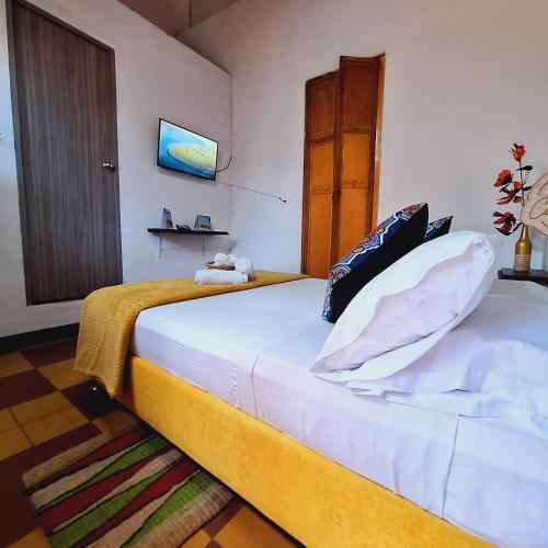 a bedroom with a large white bed in a room at Hostal Colombian Gold in San Gil