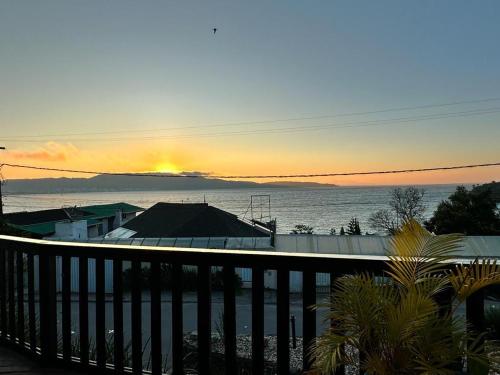 a view of the ocean at sunset from a balcony at Pousada Caminho do Mar in Bombinhas