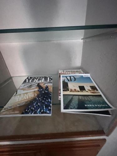 two magazines sitting on top of a shelf at House Gaudio 38 in Sanremo