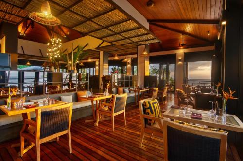 ein Restaurant mit Tischen und Stühlen und Meerblick in der Unterkunft Hilton Seychelles Northolme Resort & Spa in Beau Vallon