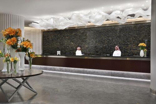 two people taking a picture in a mirror at Hilton Riyadh Hotel & Residences in Riyadh