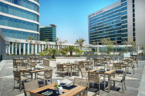 an outdoor patio with tables and chairs and buildings at Hilton Riyadh Hotel & Residences in Riyadh