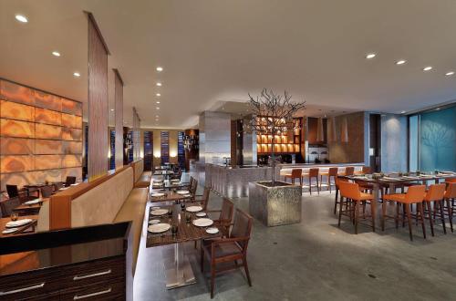 a dining room with tables and chairs in a restaurant at Hilton Riyadh Hotel & Residences in Riyadh