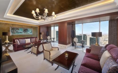 a living room with couches and a chandelier at Hilton Riyadh Hotel & Residences in Riyadh