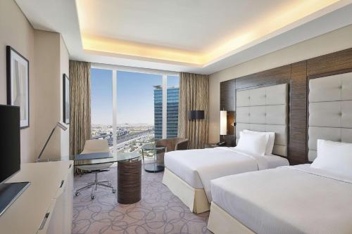 a hotel room with two beds and a view of a city at Hilton Riyadh Hotel & Residences in Riyadh