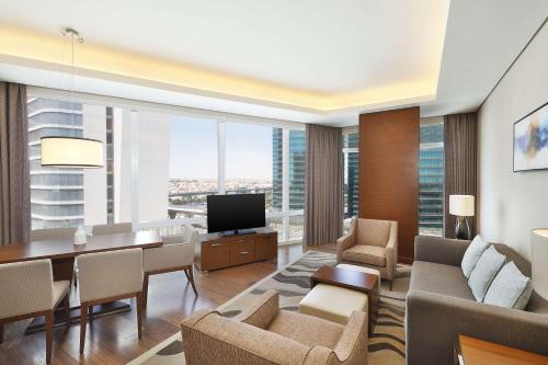 a living room with a dining table and a television at Hilton Riyadh Hotel & Residences in Riyadh