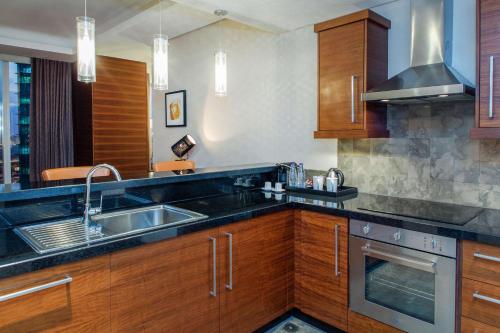 a kitchen with wooden cabinets and a sink at Hilton Riyadh Hotel & Residences in Riyadh