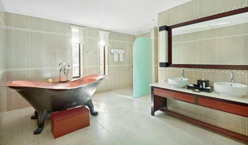 a large bathroom with a tub and two sinks at DoubleTree by Hilton Seychelles Allamanda Resort & Spa in Takamaka