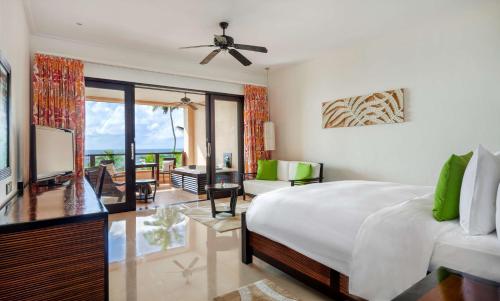 1 dormitorio con 1 cama y sala de estar en DoubleTree by Hilton Seychelles Allamanda Resort & Spa, en Takamaka