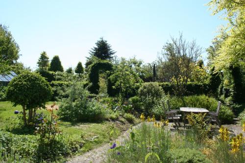 a garden with a bench and flowers and trees at BnB Thuroe in Svendborg