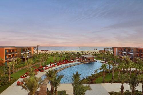 a resort with a pool and a beach with palm trees at Hilton Cabo Verde Sal Resort in Santa Maria