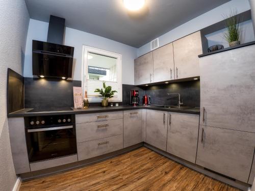 a kitchen with stainless steel appliances and wooden floors at Hexe IV in Hohegeiß