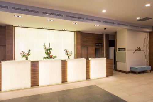 a lobby with white dividers with plants at Hilton Garden Inn Tanger City Center in Tangier